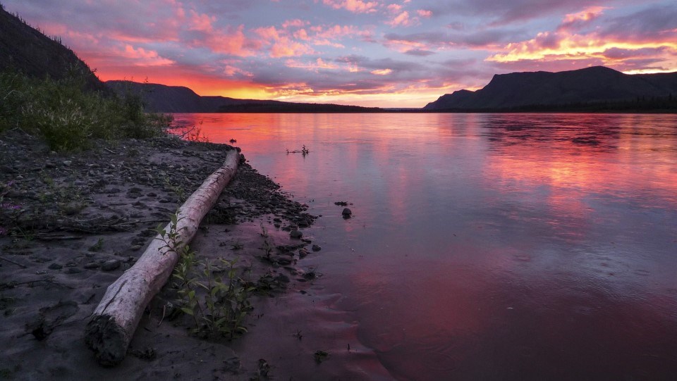 A red sunset reflects off the Yukon River